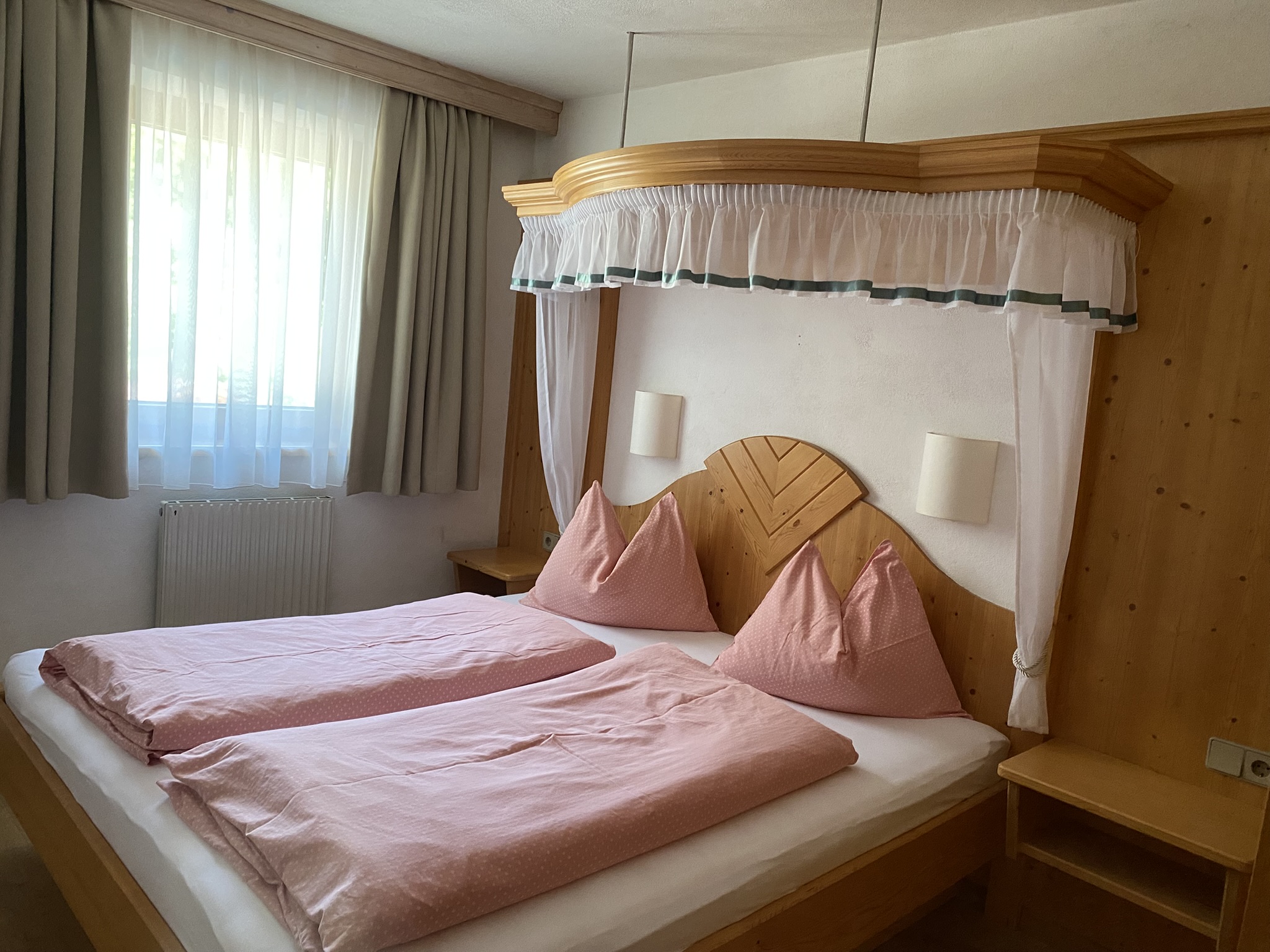 Himmelbett mit rosé-farbener Bettwäsche im Apartment Himmelschlüssel